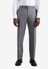 Pantalons à carreaux gris en tissu à texture lisse. Présentent une taille plate, des passants de ceinture et une fermeture à bouton unique à l'avant.