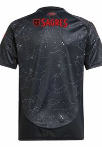 Maglia sportiva nera con un motivo di notte stellata, con linee bianche a puntini che rappresentano costellazioni. Logo "SAGRES" in rosso nella parte superiore.