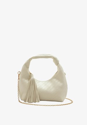 Pequeño bolso tejido blanco con asa corta, borla con flecos y correa de cadena dorada sobre fondo blanco.