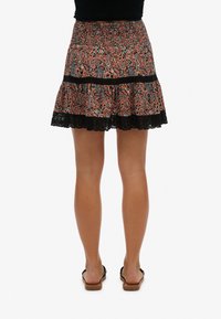 Gonna svasata con un vivace motivo paisley in arancione e blu, caratterizzata da un bordo in pizzo nero, una vita elastica e un design a strati.