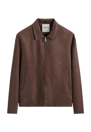 Veste zippée en daim marron avec col pointu et deux poches latérales, présentée sur fond blanc.