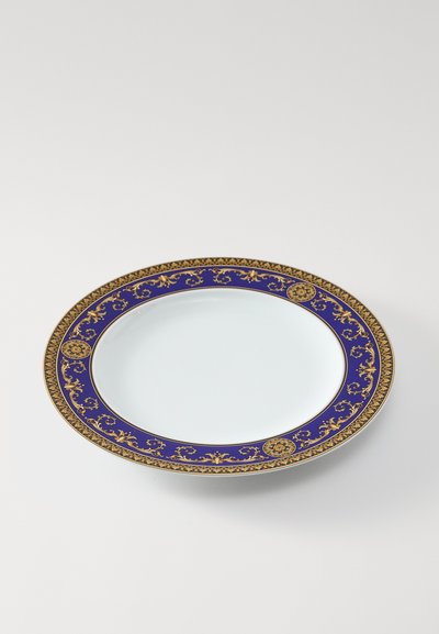 Dziļi zila porcelāna šķīvis ar zelta rotātu malu ar ziedu un ģeometriskajiem rakstiem; gluds balts centrs. Diametrs aptuveni 25 cm.