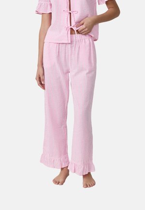 Pink checked pajama set featuring short sleeves and ruffled hem on pants. Made of lightweight fabric with a relaxed fit.