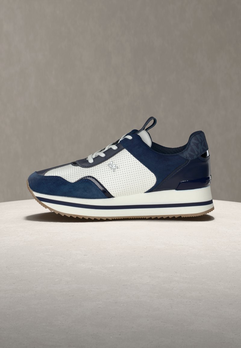 Baskets pour hommes avec des panneaux en suède bleu marine et en mesh, des accents blancs, un talon texturé, et une semelle épaisse blanche à rayures bleu marine.