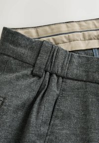 Harmaa teksturoitu kangas, jossa on ribbitetty kuvio, sisältäen sileän beigevyötärön, jossa on kontrastiväriset ompeluotsikot.