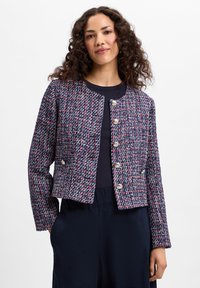 Marineblauwe en rode tweedjas met een cropped ontwerp, ronde halslijn en een sluiting met zilveren knopen aan de voorkant. Bevat textuurstof en lange mouwen.