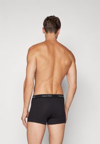 Schwarze Baumwoll-Boxershorts mit einem elastischen Bund im Markenstil. Der Stoff ist glatt und dehnbar, mit einer maßgeschneiderten Passform. Flache Nähte für zusätzlichen Komfort.