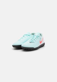 Light blue athletic shoes with textured surface, black rubber outsole, and pink swoosh accent; lace-up design with padded collar.