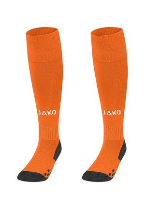 Orange knælange sportssokker med grå detaljer ved hælen og tæerne. Har mærkenavnet "JAKO" i hvidt på forsiden.
