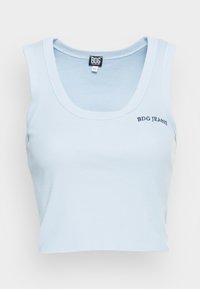 Světle modrý žebrovaný top bez rukávů s kulatým výstřihem a krátkým střihem. Na přední straně je vyšitý nápis "BDG JEANS" černou barvou.