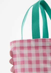 Sac fourre-tout en vichy rose et blanc avec des poignées en tissu teal et des détails festonnés sur le bord. Matériau en coton texturé.