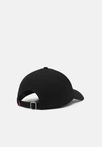 Casquette de baseball noire avec visière incurvée, texture en tissu, sangle réglable à l'arrière avec une boucle en métal argenté, sans autres détails.