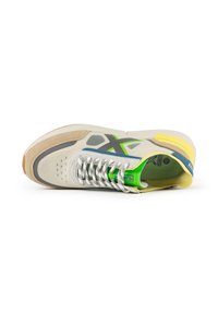 Sneaker con tomaia beige, accenti grigi, dettagli verdi e blu e un tallone giallo. Presenta una texture in rete e lacci decorati.