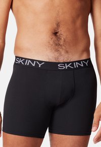 Boxer aderenti neri in cotone con un elastico in vita a marchio SKINY. Design aderente con una texture liscia e lunghezza moderata delle gambe.