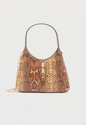 Kabelka s hadím vzorom a zaobleným tvarom, vybavená zlatým zapínaním a retiazkovým remienkom. Materiál má lesklý povrch s textúrovanými detailmi.