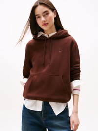 Sweatshirt capuz castanho com um bolso frontal, usado por cima de uma camisa branca com punhos riscas. Design casual, textura suave, ajuste relaxado.