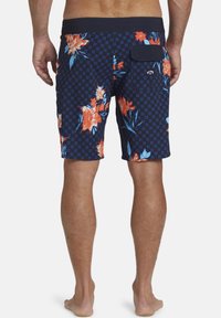 Pantaloni da bagno blu navy con motivo a scacchi e grande design floreale arancione e blu. Presentano una tasca posteriore e una vita elastica.