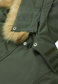 Giacca parkas verde con bordo in pelliccia sintetica, chiusura con zip, bottoni a pressione e dettagli in Velcro. Realizzata in tessuto resistente con una texture liscia.
