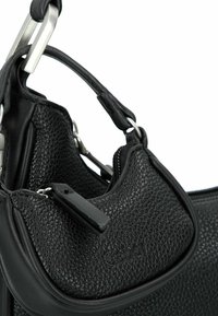 Zwart gestructureerde leren tas met een klein ritsvak, voorzien van metalen hardware en een stevig handvatontwerp.