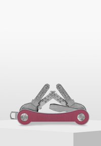 Outil multifonction avec un manche violet vif et des outils en argent métallique. Comprend plusieurs lames pliantes avec des poignées texturées pour une manipulation aisée.