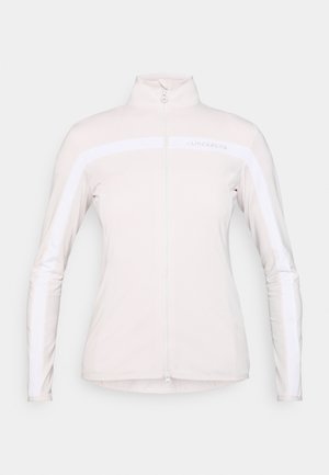 Light pink zip-up jacket made from a smooth, stretchy fabric. Features white horizontal stripes on the chest and sleeves, high collar, and slim fit.