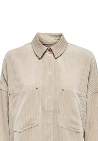 Beige Kordhemd mit spitzem Kragen, goldener Knopfverschlusss und zwei Brusttaschen. Verfügt über eine vertikale Rippstruktur im Stoff.