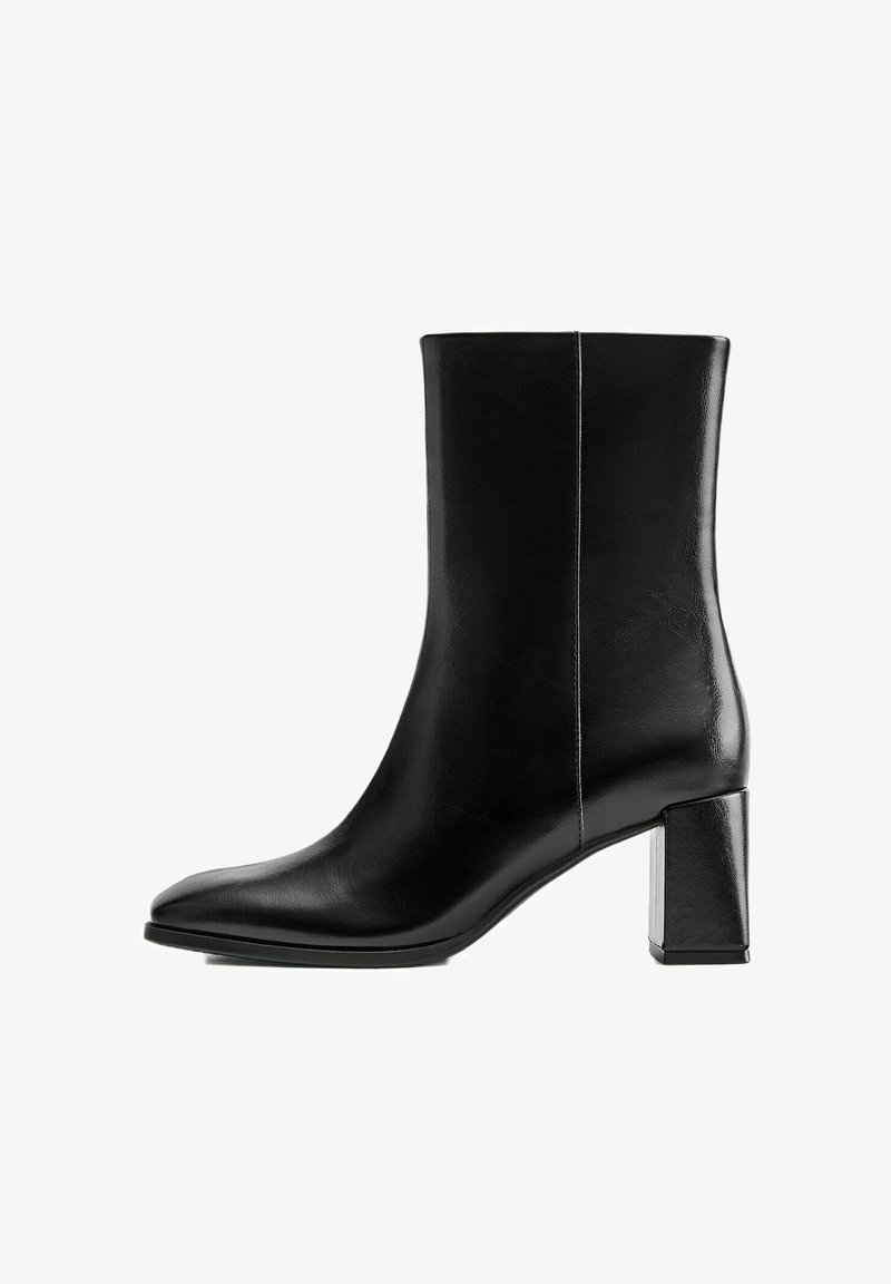 Botte noire en cuir mi-mollet avec bout pointu et talon bloc sur fond blanc, vue de côté.