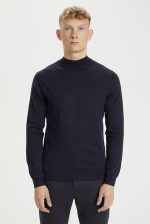 Granatowy sweter wykonany z miękkiej dzianiny, z wysokim okrągłym dekoltem i długimi rękawami, z prążkowanymi mankietami i dołem dla lepszego dopasowania.