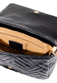 Borsa a tracolla in pelle nera con trapuntatura, con il pattino aperto che mostra l'interno in tessuto beige e la tasca interna con zip.
