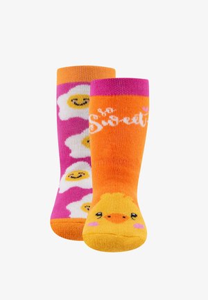 Bunte Kindersocken: eine rosa mit weißen Eimuster, die andere leuchtend orange mit einem Küken-Design und dem Text "Sweetie." Strukturiertes Strickmuster.