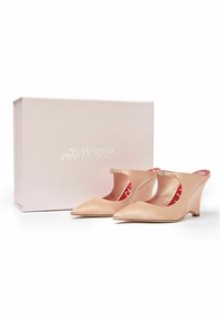 Nude satynowe buty na koturnie z szpiczastym noskiem i wycięciami po bokach, z małym paskiem i czerwonym wnętrzem, zaprezentowane w jasnoróżowym pudełku.