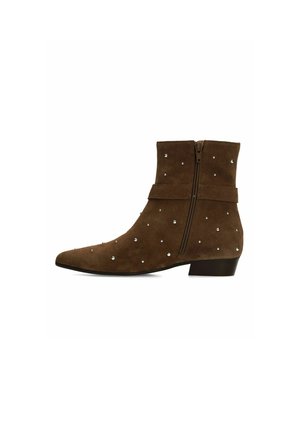 Brown suede ankle boot with low heel, side zipper, decorative silver studs, and strap detail around the ankle.