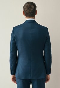 Dunkelblazer aus strukturiertem Stoff. Verfügt über einen einzigen Schlitz, Reverskragen und Knopfdetails an den Ärmeln. Taillierte Passform, elegantes Design.