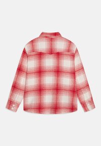 Karierte Bluse in Rot und Weiß mit langen Ärmeln, einem Button-Down-Kragen und einem abgerundeten Saum. Das Material wirkt leicht mit einer strukturierten Oberfläche.