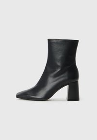 Black leather ankle boot with a pointed toe, smooth texture, and a chunky block heel. Simple design, no visible hardware or accents.