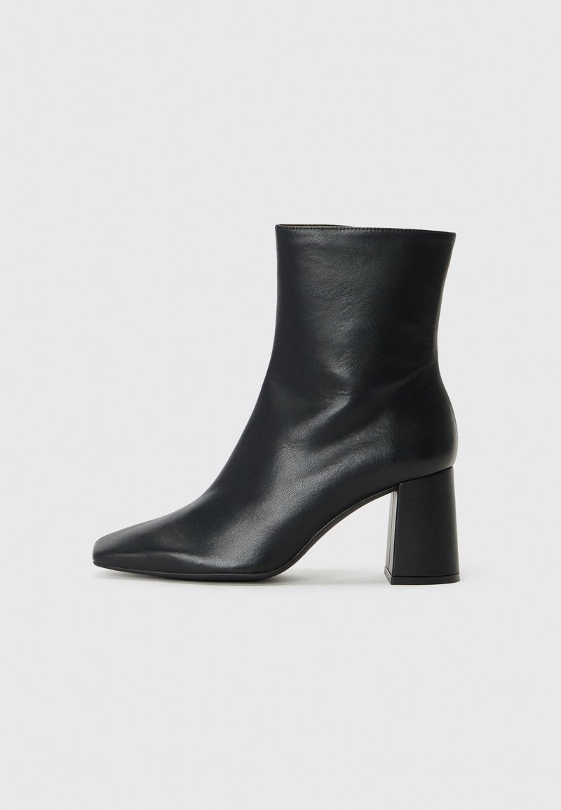 Black leather ankle boot with a pointed toe, smooth texture, and a chunky block heel. Simple design, no visible hardware or accents.