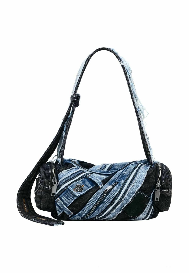 Bolsa de mezclilla con forma cilíndrica, que combina telas azules y negras, múltiples cremalleras y bordes deshilachados para darle textura.