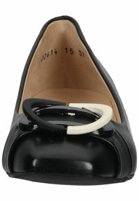 Chaussure plate en cuir noir avec boucle ronde noire et blanche sur le bout et intérieur beige affichant les numéros de taille.