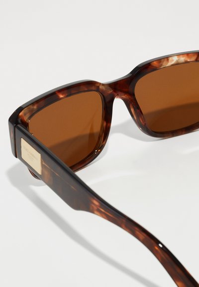 Tortoiseshell sunglasses with brown lenses. Square frames, glossy finish, featuring a metallic accent on the temple.