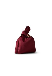Burgundy textured fabric bag with a knotted top and gold hardware detailing. The design is compact and structured, featuring a dual-compartment shape.