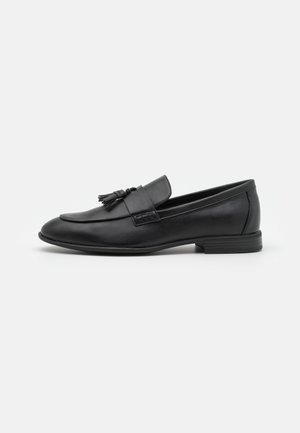 Schwarze Lederloafer mit glatter Oberfläche, verziert mit einer Quastenakzent an der Vorderseite, runder Zehenform und niedrigem Absatz. Einfaches und elegantes Design.