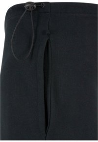 Sorte joggingbukser med snøre i taljen, der inkluderer en sidelommer. Fremstillet af et blødt, glat stof med et regular fit design.