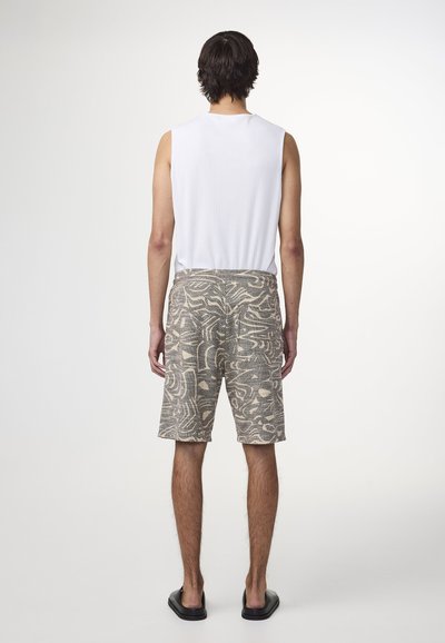 Vit ärmlös topp, grå shorts med abstrakt beige mönster. Slim fit med sidofickor, platt midjeband och platta sömmar. Svarta sandaler.