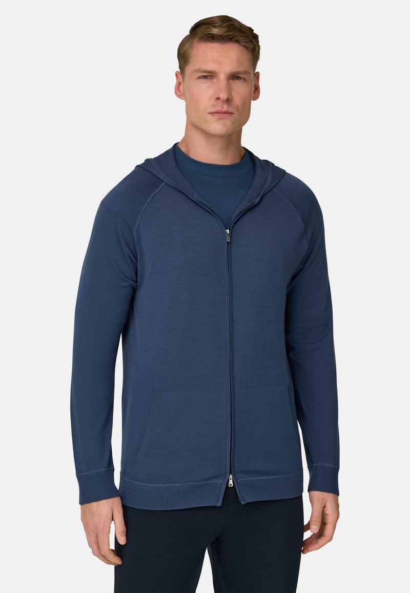 Sweat à capuche zippé bleu marine avec une finition texturée, poches avant et capuche. Comprend des poignets et un ourlet côtelés, fabriqué dans un tissu doux.
