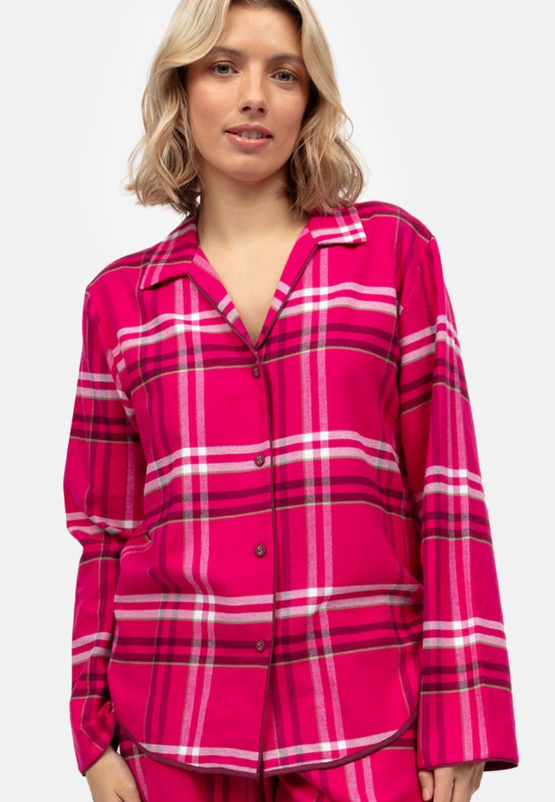 Il pigiama di flanella rosa presenta un grande motivo a quadri con strisce bianche e rosa scuro, maniche lunghe e una chiusura frontale con bottoni.