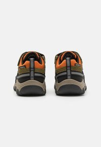 Schwarze und olivgrüne Wanderschuhe mit orangefarbenen Akzenten, ausgestattet mit einem strukturierten Obermaterial, gepolstertem Schuhkragen und einer robusten Sohle für besseren Halt.