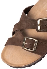 Brown suede sandal featuring two adjustable straps with gold-tone buckles, contoured footbed, and textured rubber outsole.