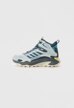 Botte de randonnée bleu clair en matériaux synthétiques, dotée d'un embout renforcé, d'un système de laçage texturé et d'une semelle en caoutchouc antidérapante. Marque Merrell visible.