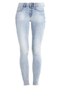Jeans ajustados de color azul claro con un acabado desgastado, que cuentan con una cinturilla alta, cinco bolsillos y una textura de mezclilla clásica.