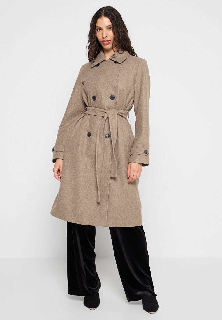 Trench coat in misto lana color marrone chiaro con vita avvolta da una cintura, design doppiopetto, bottoni neri e maniche ampie.